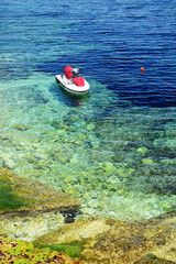 The turquoise sea water is near beach and water jet bike, Bugibba, Malta