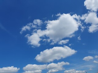 Blue sky with fluffy white clouds on a sunny summer day, beauty