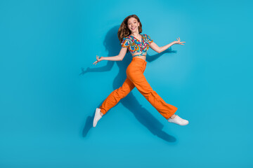 Full body portrait of lovely young girl jump empty space wear top isolated on blue color background