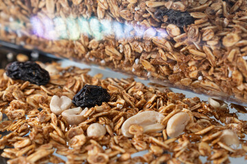 Stack of granola with pieces of peanuts and raisins.