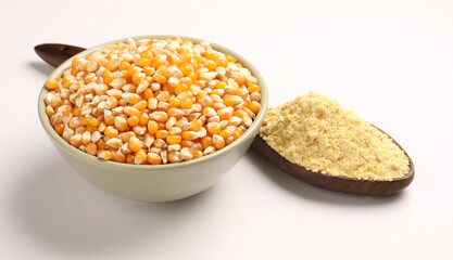 Corn flour in wooden spoon with dried corn in bowl. corn ingredients