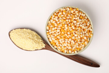 Corn flour in wooden spoon with dried corn in bowl. corn ingredients