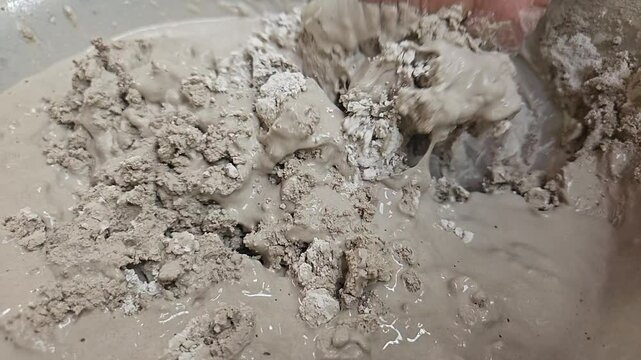 Clay Artist Mixing Plaster Of Paris And Water In A Bowl To Make Plaster Mold, India
