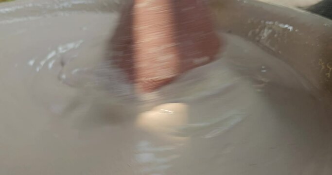 Hand Of An Sculptor Mixing Plaster Of Paris And Water In A Bowl To Make Plaster Mold, India