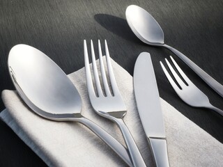 Minimalist silverware: close-up of a fork, knife, and spoon on a folded napkin