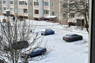 Fototapeta premium The picture shows cars with snow on them. View from above. Winter.