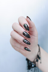 Female hands with long nails and black and red nail polish