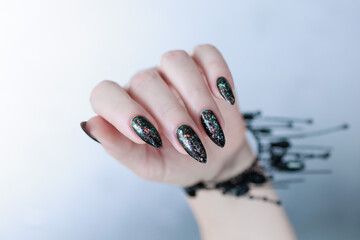 Female hands with long nails and black and red nail polish