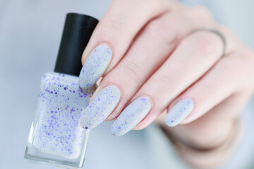 woman hands with long nails light gray blue manicure