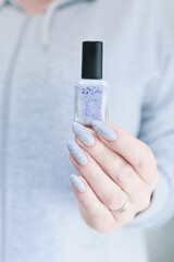 Female hand with long nails gray manicure