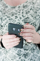 Woman's hands holding a large black smartphone