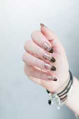 Woman's hands with long nails and white and black thermo manicure