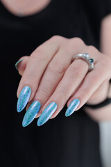 Woman's beautiful hand with long nails and light blue manicure