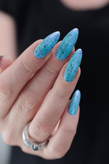 Woman's beautiful hand with long nails and light blue manicure
