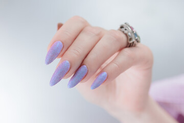 Woman hand with long nails manicure and light pink lilac nail polish