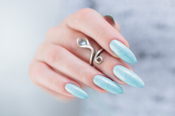 Woman's beautiful hand with long nails and light baby blue manicure