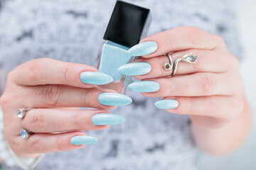 Woman's beautiful hand with long nails and light blue manicure