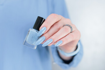 Fototapeta premium Woman's beautiful hand with long nails and light baby blue manicure