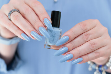 Woman's beautiful hand with long nails and light baby blue manicure