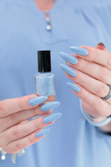 Woman's beautiful hand with long nails and light baby blue manicure
