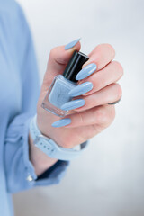 Woman's beautiful hand with long nails and light baby blue manicure