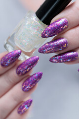 Female hand with long nails and purple plum manicure