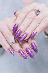 Female hand with long nails and purple plum manicure
