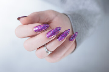 Female hand with long nails and purple plum manicure