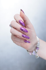 Female hand with long nails and purple plum manicure