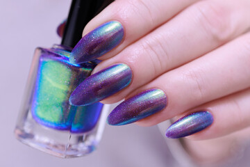 beautiful female hand with long nails, golden, purple and blue manicure	