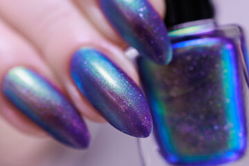 beautiful female hand with long nails, golden, purple and blue manicure	