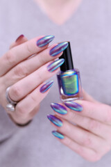 beautiful female hand with long nails, golden, purple and blue manicure	