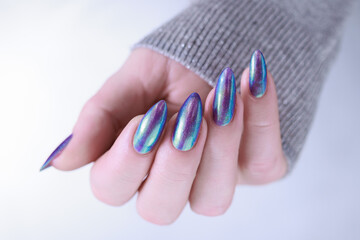 beautiful female hand with long nails, golden, purple and blue manicure	