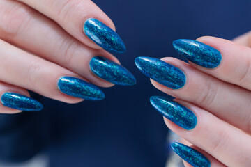 Woman's beautiful hand with long nails and bright blue manicure