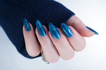 Woman's beautiful hand with long nails and bright blue manicure 