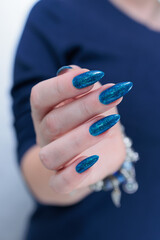 Woman's beautiful hand with long nails and bright blue manicure 