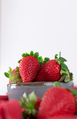 Fresh strawberries in ceramic bowl on white background