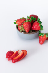Fresh strawberries in ceramic bowl on white background