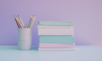 Stack of books on a white desk with a pastel lavender background