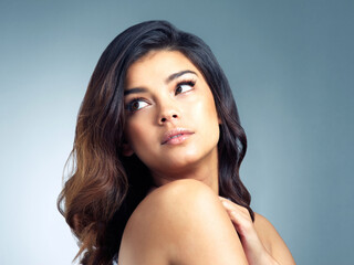 Naklejka premium Hair care, thinking and woman in studio with treatment for idea, salon or shampoo glow on gray background. Body, aesthetic and young model in thought for remember, fresh texture or cosmetics