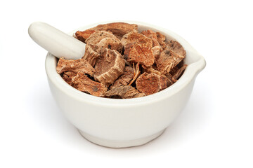 Close-up of Dry Organic Semal Musli (Bombax Mulabaricum) herb, in white ceramic mortar and pestle, isolated on a white background.