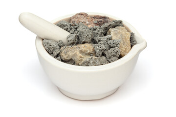Close-up of Dry Organic Alkaline Salt or Sajji Khar (Seidlitzia stocksii), in white ceramic mortar and pestle, isolated on a white background.