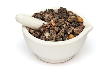 Close-up of Dry Organic Gooseberry (Phyllanthus emblica) or Amla, in white ceramic mortar and pestle, isolated on a white background.