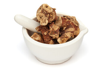 Close-up of Dry Organic Kulanjan (Alpinia galanga) roots, in white ceramic mortar and pestle, isolated on a white background.