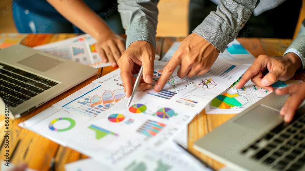 Poster team analyzing data charts and graphs on a wooden desk. collaborative business strategy meeting. con
