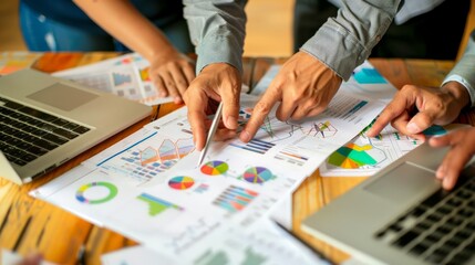 Team analyzing data charts and graphs on a wooden desk. Collaborative business strategy meeting. Concept for financial growth and digital marketing