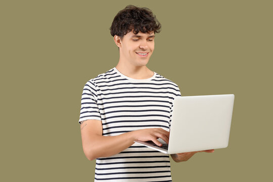Male programmer working with laptop on green background