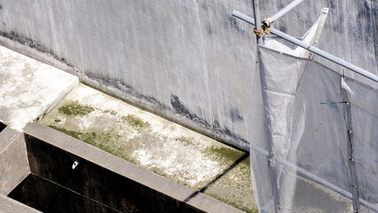 Building balcony, drainage area above the building with moss on the surface of the concrete wall.