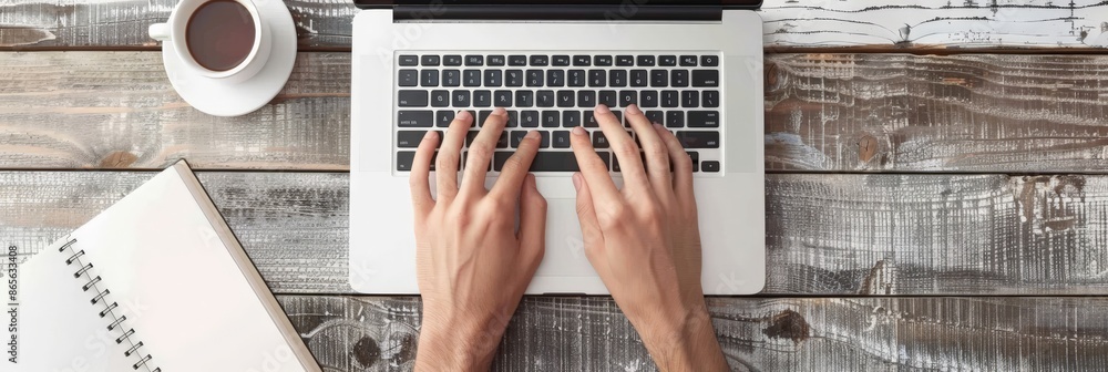 Poster person typing on a laptop with a coffee cup and notebook on a wooden surface. suitable for business 