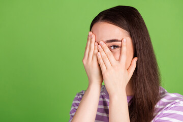 Photo portrait of pretty young girl hide face peek eye wear trendy striped violet outfit isolated on green color background